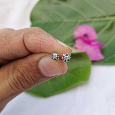 Side view of pink floral stud earring worn on lobe hypoallergenic comfort