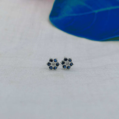 7mm blue flower stud worn on helix piercing on white
